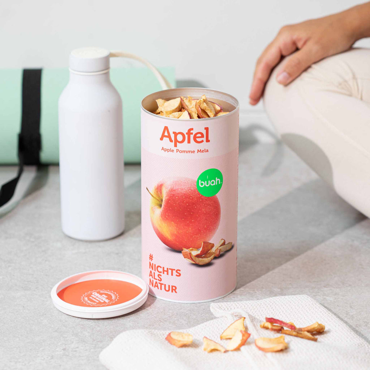 buah grosse Dose Apfel steht auf Boden neben Sportgeraeten