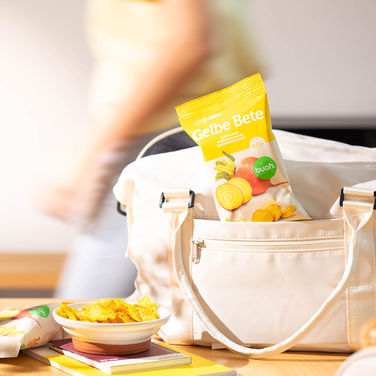 buah Gelbe Bete Gemuesechips stecken im Fach einer Tasche mit buah Gemuesechips in einer Schale im Vordergrund