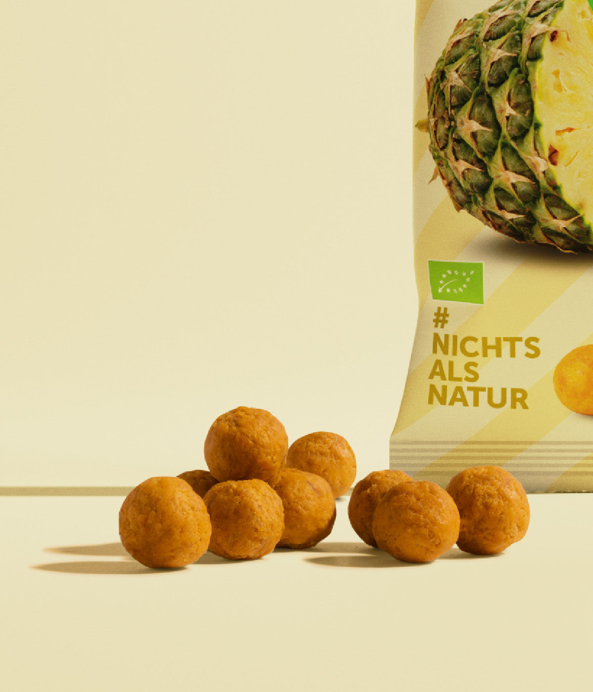 kleine, runde gelbliche Ananas Kaubonbon neben einer Packung Kaubonbons von buah