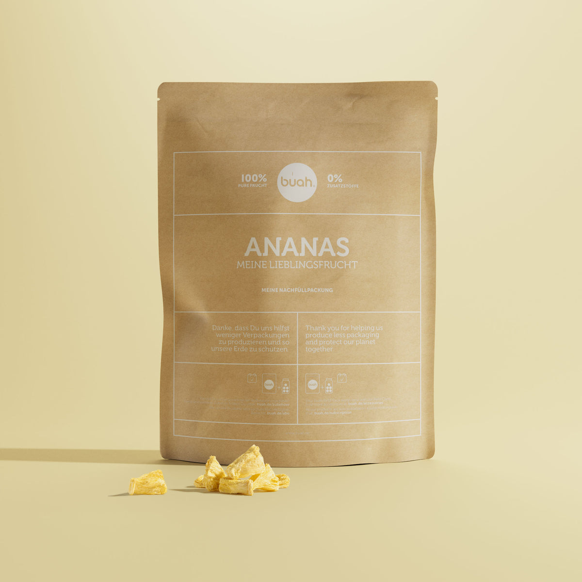 Ananas Refiller von buah in einer braunen Papierverpackung vor gelbem Hintergrund