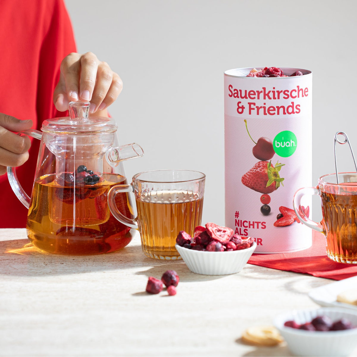 Dose Sauerkirsche & Friends von buah neben Teekanne mit Tee aus buah Fruechten