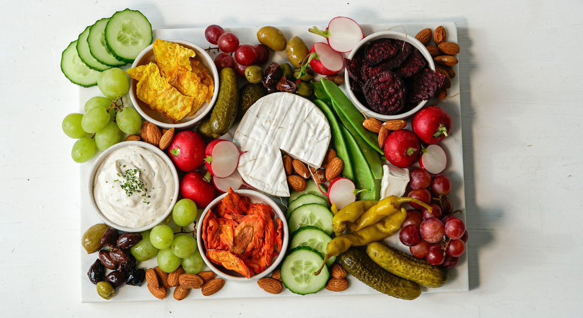 Snackboard mit frischem Gemuese, Obst und buah vakuumgetrocknetem Gemuese in Schalen