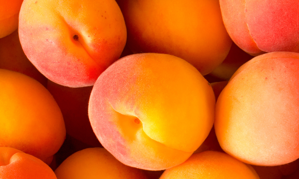 Viele frische orangene Aprikosen lieben auf und nebeneinander