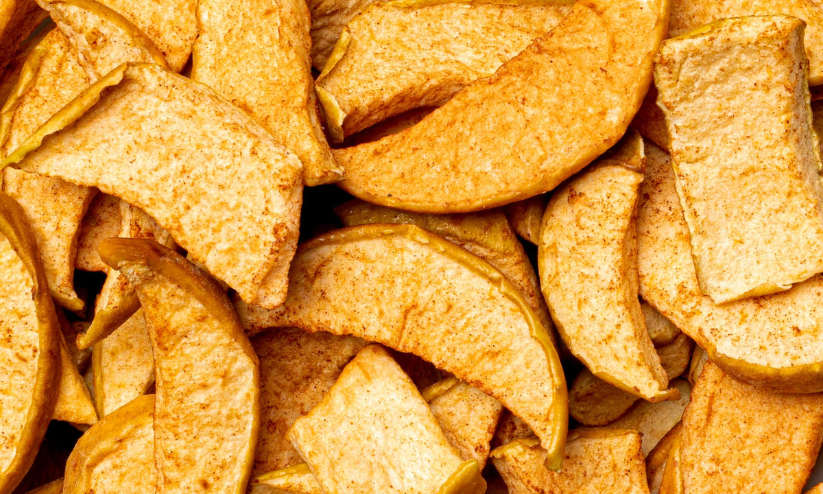 Viele Stuecke gefriergetrockneter buah Apfel mit Zimt, die auf und nebeneinander liegen