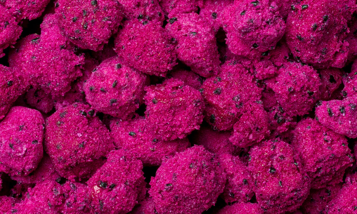 Viele Wuerfel pinker buah gefriergetrockneter Drachenfrucht liegen auf und nebeneinander