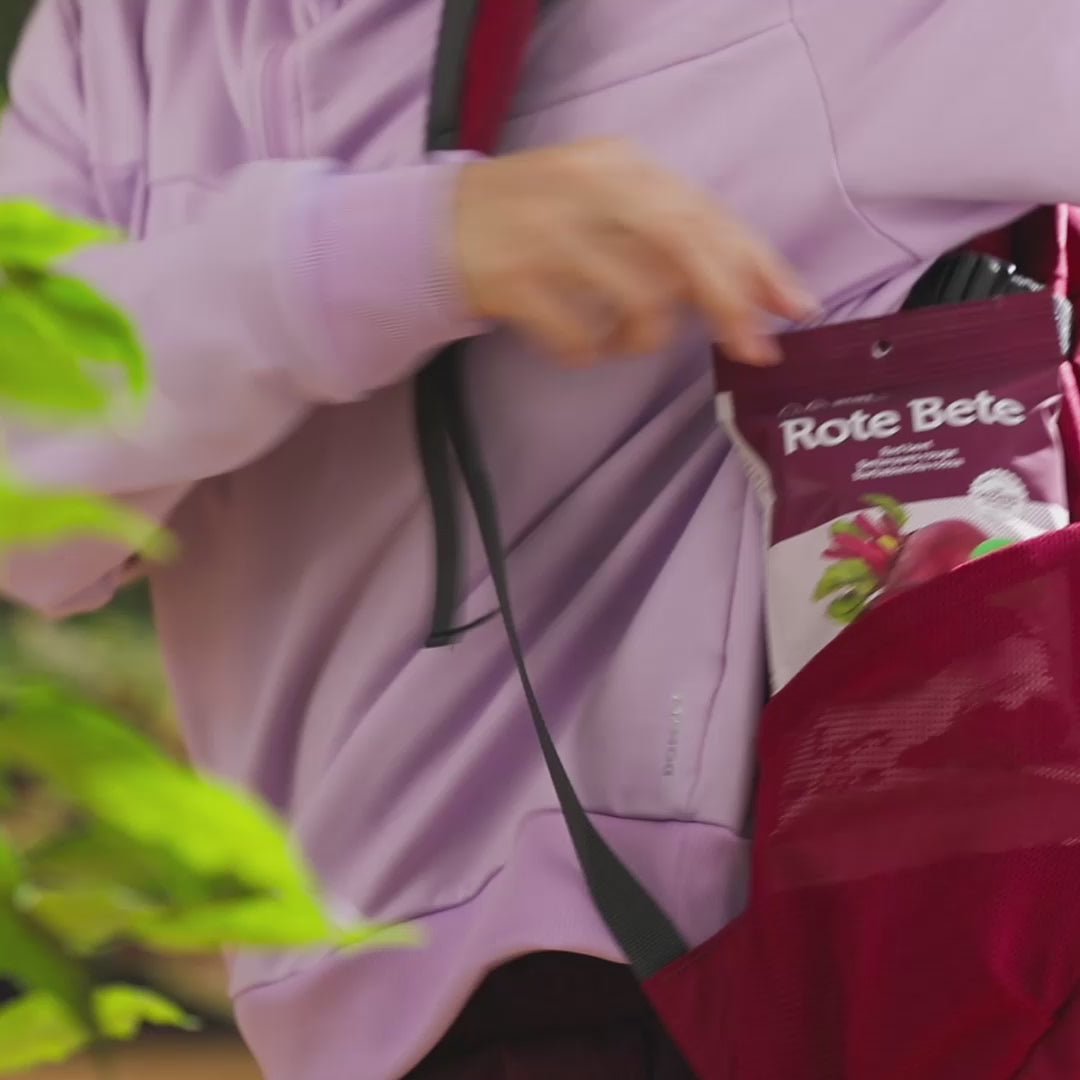 Video einer Wanderin die eine Packung buah Rote Bete Gemuesechips aus Ihrem Rucksack nimmt
